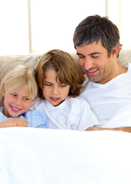 Attentive father and his children reading book — Stock Photo, Image