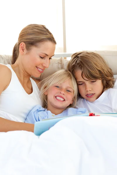 Mooie moeder en haar kinderen lezen van boek — Stockfoto