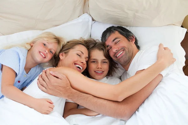 Geanimeerde familie knuffelen in de slaapkamer — Stockfoto