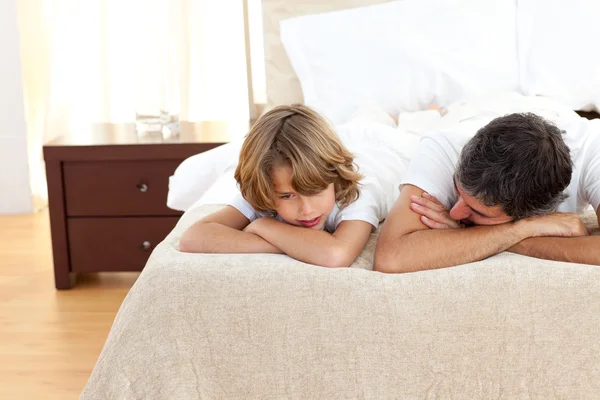 Ojciec Nozdrzany rozmowa z synem, leżąc na łóżku — Zdjęcie stockowe