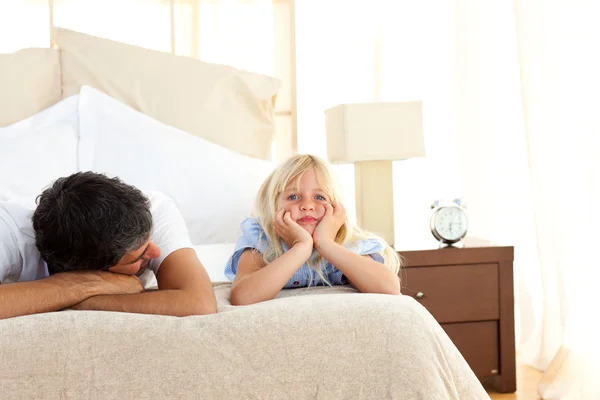 Sorgliga lilla flickan liggande på sängen med hennes far — Stockfoto