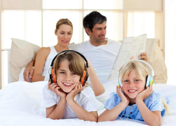 Lindos hermanos escuchando música con auriculares —  Fotos de Stock