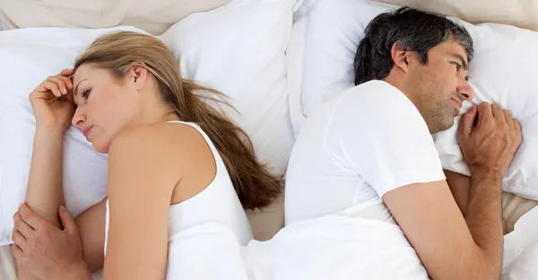 Couple bouleversé dormant séparément — Photo