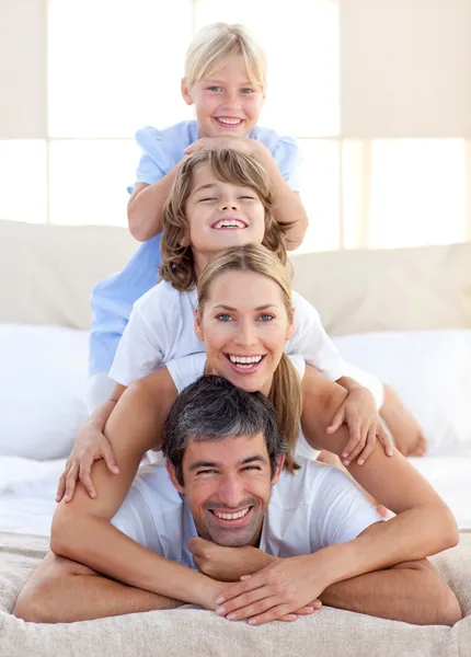 Счастливая семья веселится на кровати — стоковое фото