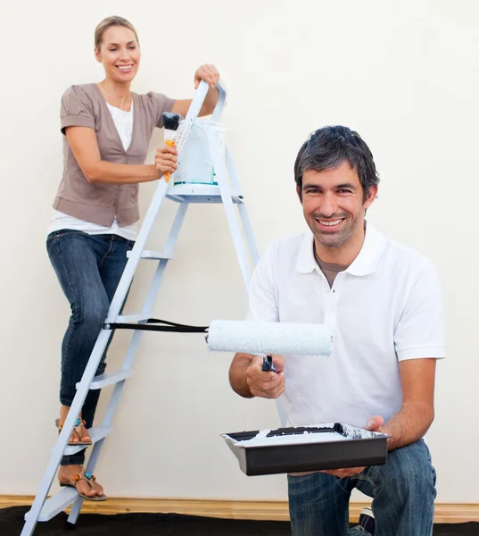 Happy man and woman decorating a room — Stock Photo, Image