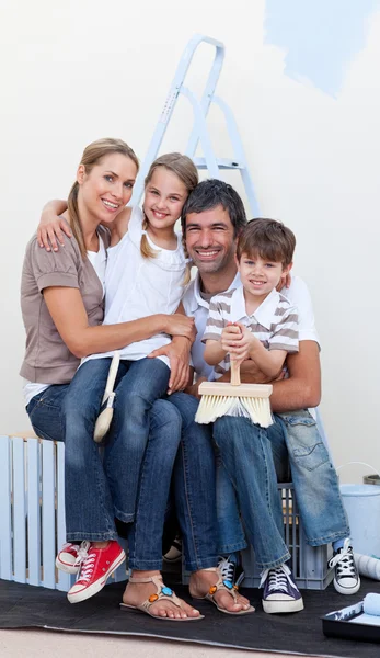 Retrato de uma família feliz decorando um quarto — Fotografia de Stock