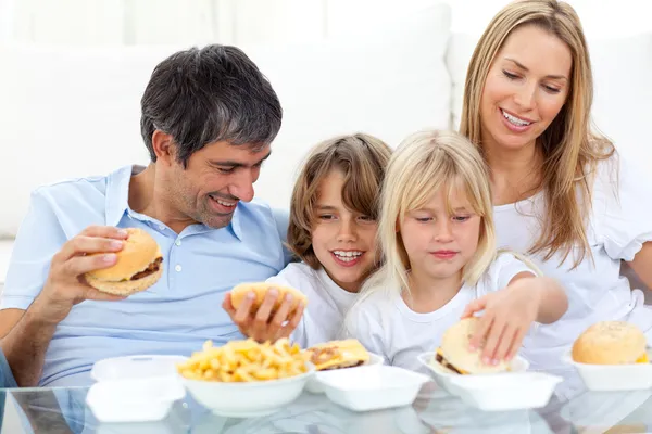 Glada familjen äter hamburgare — Stockfoto