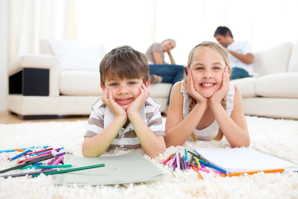 Merry siblings drawing lying on the floor — Stock Photo, Image