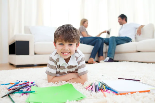 Smiling child drawing lying on the floor — Stock Photo, Image