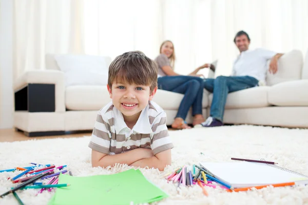 Schattige kleine jongen tekening op de vloer liggen — Stockfoto