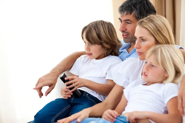 Молодая семья смотрит телевизор — стоковое фото