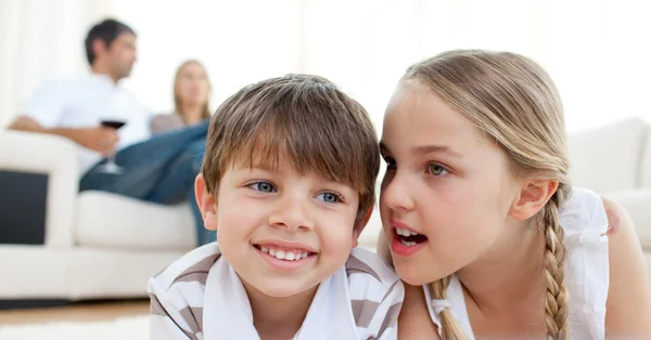 Little girl telling a secret to her brother — Stock Photo, Image