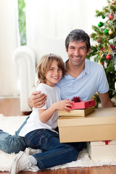 Отец и его сын держат рождественские подарки — стоковое фото