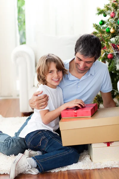 Little boy opening Christmas gifts with his father — Stok fotoğraf
