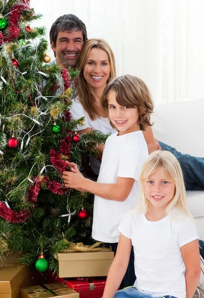 Retrato de uma família feliz decorando uma árvore de Natal — Fotografia de Stock