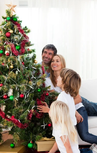 Happy family decorating a Christmas tree — Stock Photo, Image