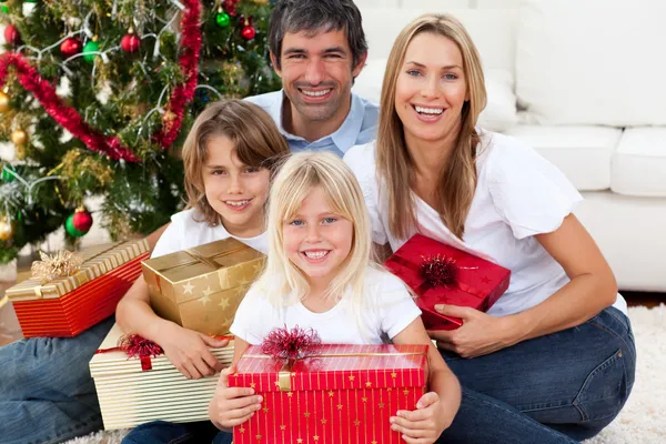 Sorrindo família segurando presentes de Natal — Fotografia de Stock