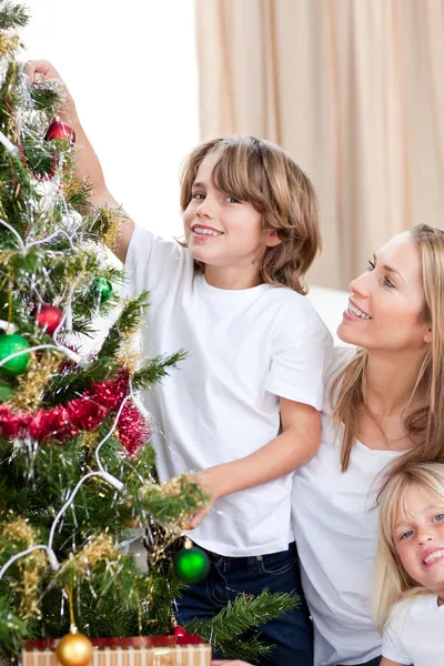 Μητέρα και τα παιδιά της διακόσμησης ενός χριστουγεννιάτικου δέντρου — Φωτογραφία Αρχείου