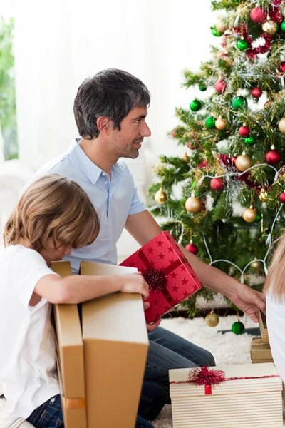 Otec a jeho syn rozbalování vánočních dárků — Stock fotografie