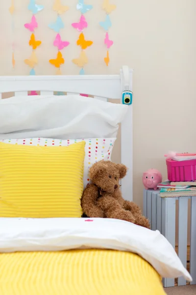 Child's bedroom with a teddy bear on the bed — Stock Photo, Image