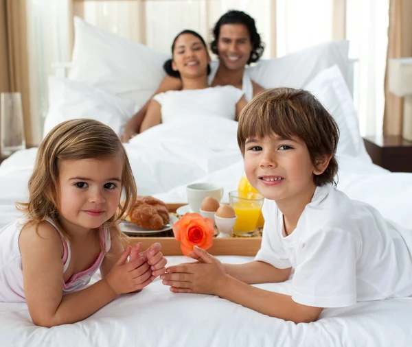 Familia sonriente desayunando en el dormitorio —  Fotos de Stock