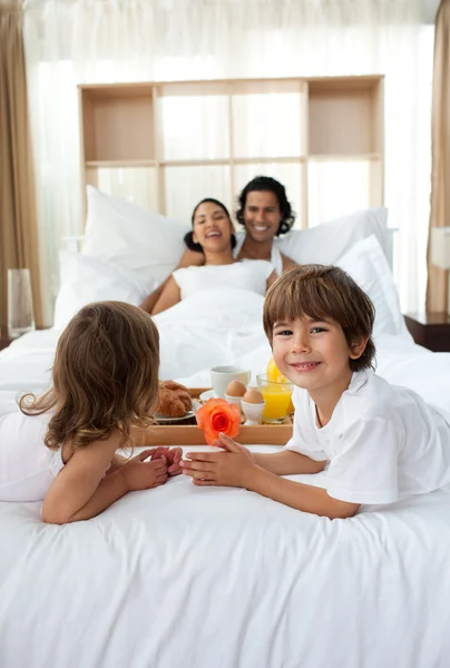Happy children bringing a breakfast to their parents — Stock Photo, Image