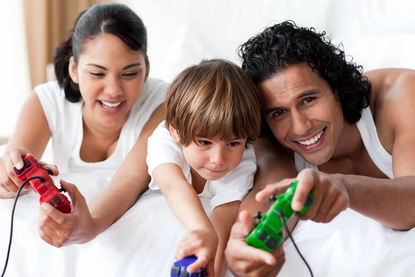 Retrato de padres sonrientes jugando videojuegos con su hijo —  Fotos de Stock