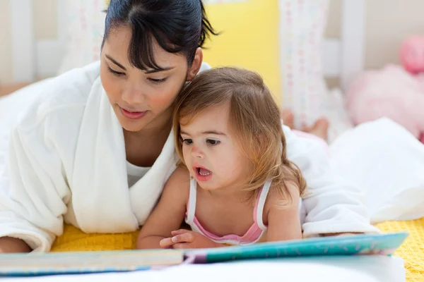 Mère attentive lisant avec sa petite fille — Photo