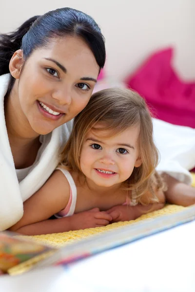 Крупный план красивой маленькой девочки и ее матери, читающей буу — стоковое фото