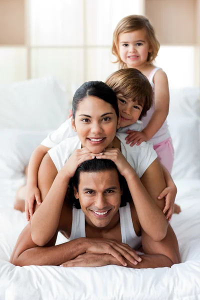 Молодая семья веселится на кровати — стоковое фото