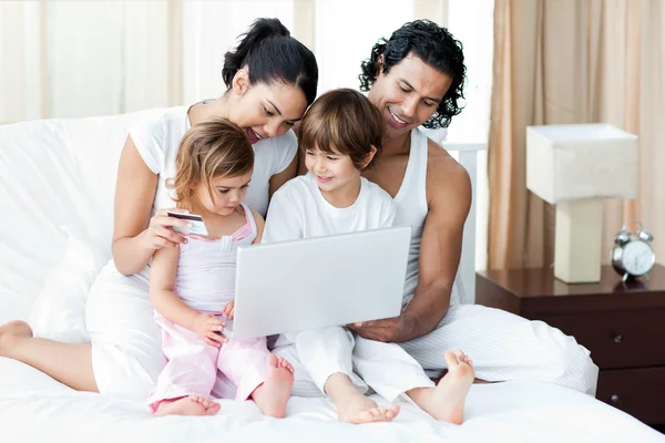 Ung familj med ett kreditkort handla online — Stockfoto
