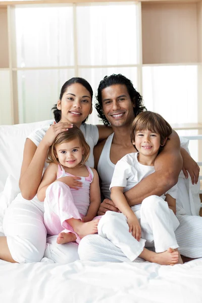 침대에 앉아 웃는 가족의 초상화 — 스톡 사진