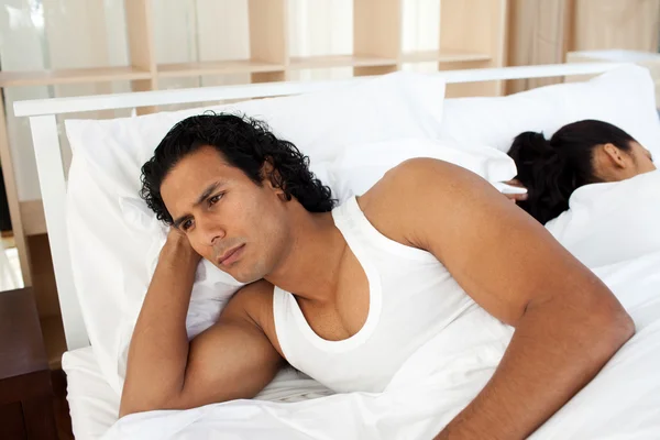 Zdenerwowany mężczyzna w łóżku śpi oddzielne kobiety — Zdjęcie stockowe