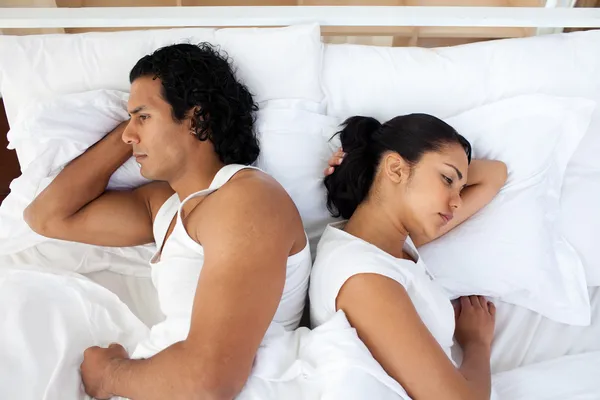 Расстроенная пара в постели спит отдельно — стоковое фото