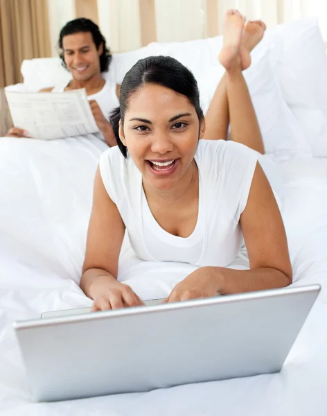 Mujer joven usando un portátil sonriendo a la cámara —  Fotos de Stock