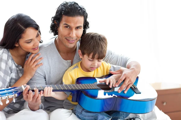 Milý chlapeček hrál na kytaru s rodiči — Stock fotografie