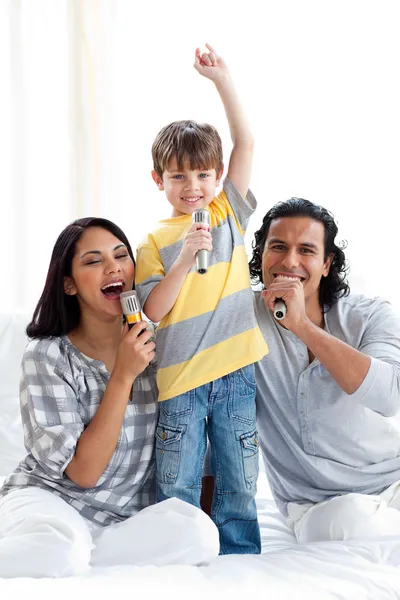 Jeune famille vivante chantant avec des micros — Photo