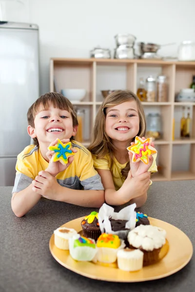 Cute siblings showing their cookies — Stock Photo, Image