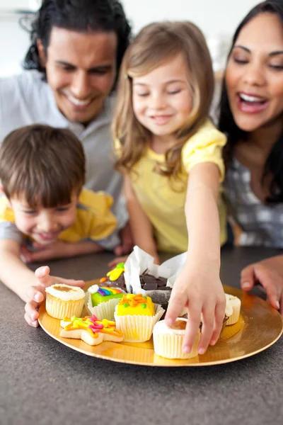 Familia alegre comiendo galletas — Foto de Stock