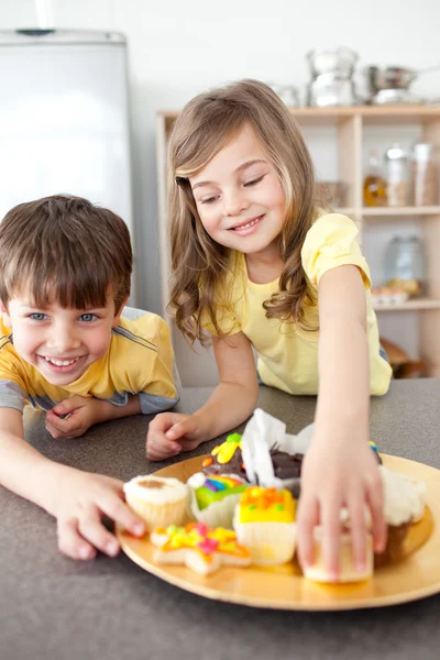 Syster och bror äta kakor — Stockfoto