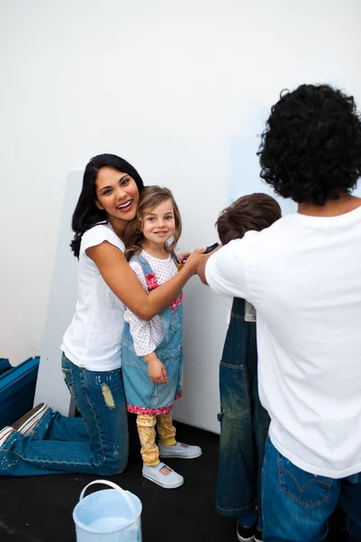 Genitori allegri con i loro figli che dipingono una stanza — Foto Stock