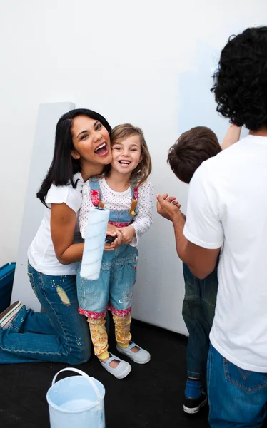 Lyckliga föräldrar med sina barn måla ett rum — Stockfoto