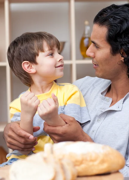 Ładny mały chłopiec i jego ojciec cięcia chleba — Zdjęcie stockowe