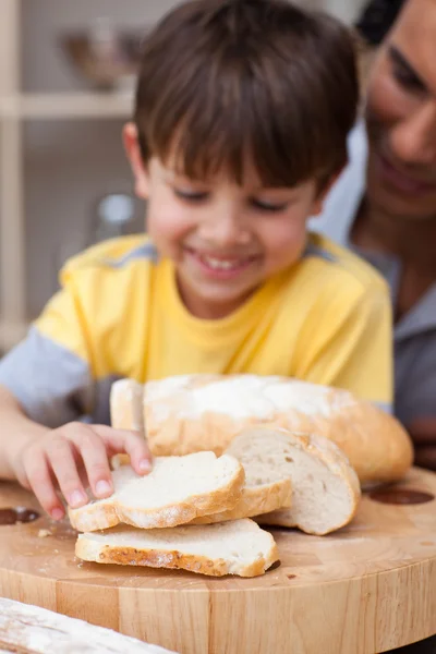 Adorable little boy eating bread with his father — Stock Photo, Image