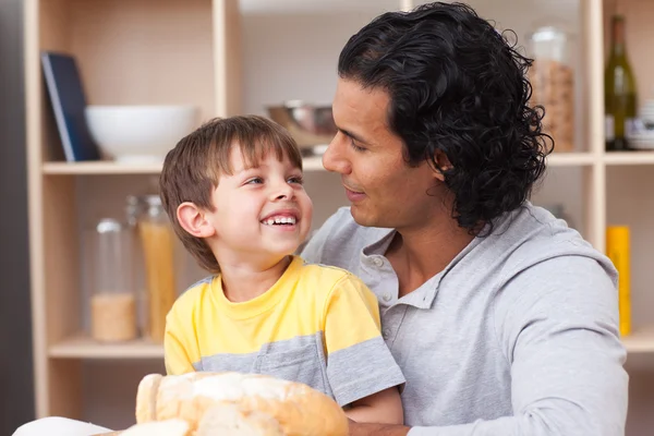 Cheerful child eating bread with his father — Stock Photo, Image