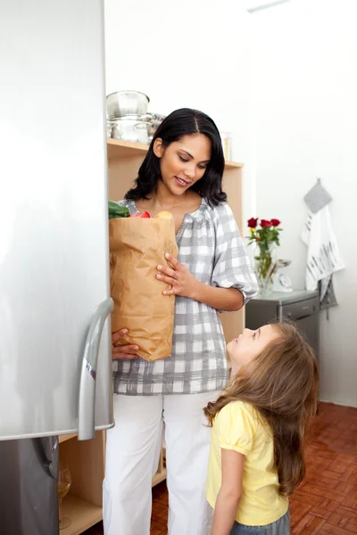 快乐小女孩开箱食品杂货袋与她的母亲 — 图库照片