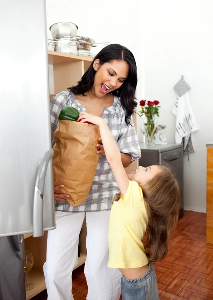 Loira menina desfazendo as malas de supermercado com sua mãe — Fotografia de Stock