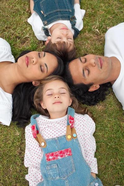 Mutlu aile uyumayı çim üzerinde yalan — Stok fotoğraf