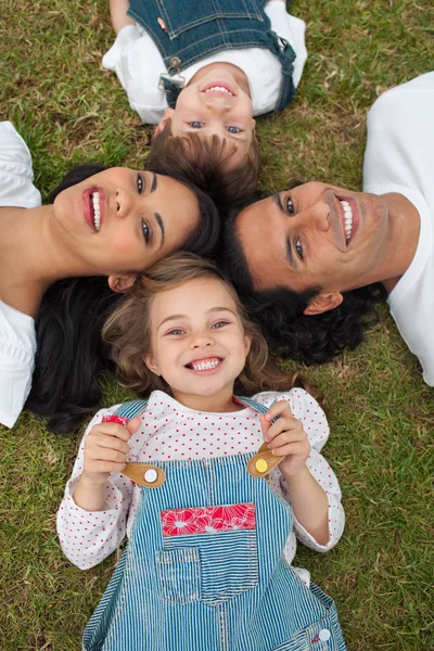 Küçük kız bir parkta ailesiyle birlikte bir daire içinde yalan — Stok fotoğraf