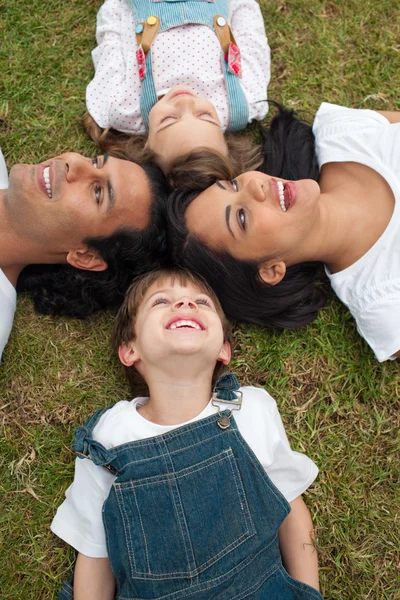 Słodkie dzieci i ich rodziców, leżąc na trawie — Zdjęcie stockowe